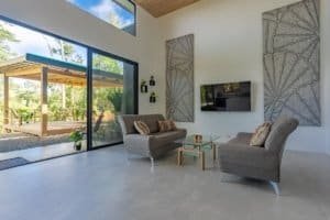 Contemporary living room with large sliding glass doors to outdoor patio in Dominical real estate.