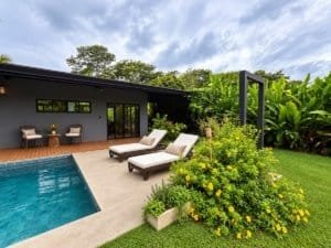 Modern tropical home with pool, outdoor seating, and lush garden in Dominical.