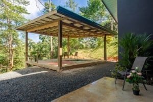 Dominical area creekside covered patio, outdoor seating and greenery.