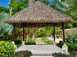 Lush tropical garden with thatched gazebo and pathway in Dominical.