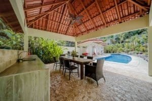 Covered outdoor patio with dining area and pool in Dominical, Costa Rica.