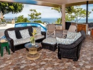 Covered patio with outdoor furniture, ocean view, and tropical rainforest in Dominical.