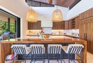 Modern kitchen with wooden cabinets, island, and pendant lights.