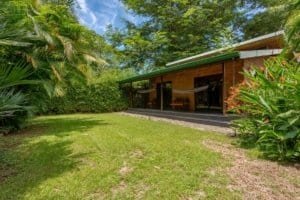 Turn-key coastal home with a covered patio in lush tropical garden.