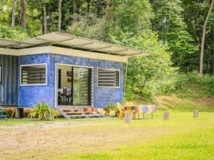Colorful container home with terraces in lush green surroundings in Costa Rica.