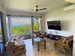 Spacious living room with ocean view, tropical decor, and modern amenities.