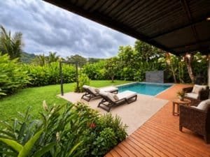 Beautiful tropical home with pool, outdoor seating, and lush garden near the beach.