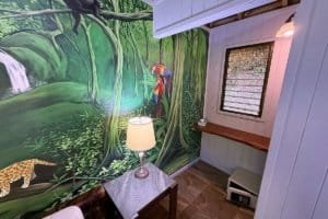 Cozy interior with jungle mural, window, and small desk in Dominical.
