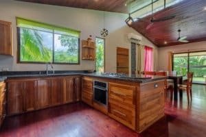 Turn-key coastal kitchen with wood cabinetry and island in Dominical Real Estate.