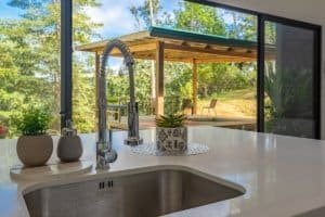 Creekside wooden patio and outdoor dining with lush greenery in Dominical area.