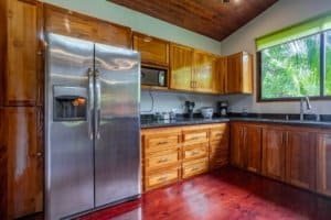 Turn-key coastal kitchen with stainless refrigerator and granite countertops.