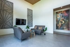 Spacious modern living room with two gray sofas, wall art, and a flat-screen TV.