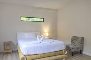 Elegant bedroom with ocean view, white bedding, and tropical decor in Dominical.