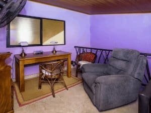 Cozy living room with armchair, desk, and ocean view window in Dominical.