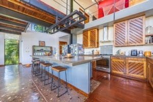 Dominical real estate: modern kitchen with island, wooden cabinets, stainless appliances, and open,.