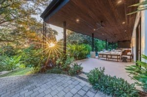 Luxurious covered outdoor living area with seating and garden at sunset in Dominical.