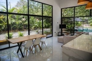 Bright open living area with floor-to-ceiling windows and modern dining table.