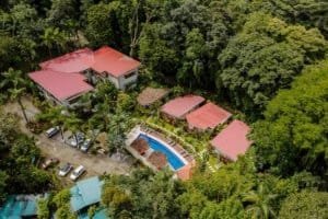 Aerial view of a private villa with pool surrounded by lush forest in Dominical.