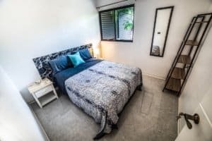 Cozy Dominical bedroom with queen bed, blue accents, near window and wardrobe.