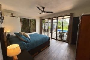 Bedroom with large sliding glass doors to pool and outdoor seating area.
