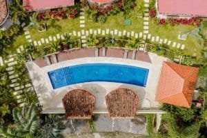 Aerial view of a private villa with a large swimming pool and lush garden.