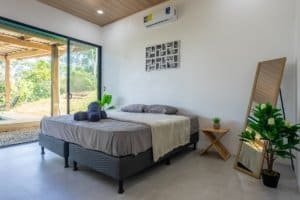 Spacious master bedroom with large sliding glass doors to outdoor patio, minimalist decor, and a sun.