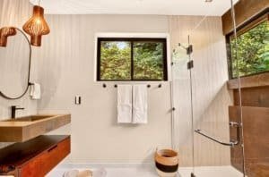 Dominical luxury bathroom with walk-in shower, double sink, and natural light.