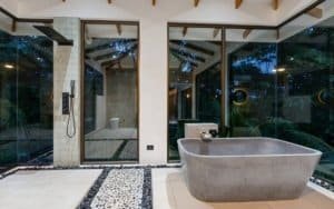 Modern tropical home with private pool and expansive glass walls.