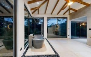 Open, bright lobby with skylight, wooden beams and large glass walls in Dominical area.