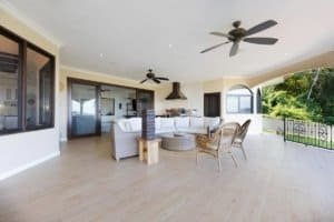 Spacious living room with ocean view, ceiling fans, and outdoor balcony.