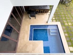 Modern pool with ocean view, outdoor patio, and garden in Dominical.