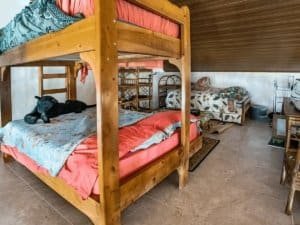 Interior of a bedroom with wooden bunk beds, a small bed, and tropical decor.