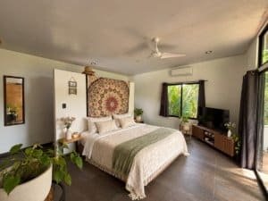 Cozy bedroom with tropical decor, large windows, and pool view near the beach.