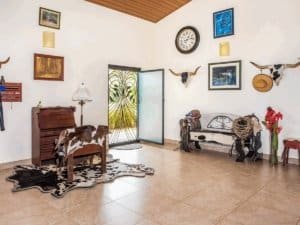 Living room with cowhide rug, wall art, and tropical decor in Costa Rica.
