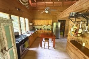 Rustic kitchen with wooden cabinets, stainless steel appliances, and natural light.