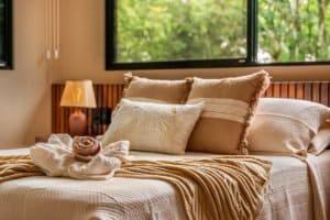 Luxury bedroom with plush beige bedding and natural light in Costa Rica.
