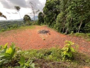 Ridge top land clearing with panoramic ocean view and surrounding forest in Costa Rica.