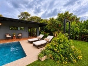 Beautiful tropical home with pool, lounge chairs, and lush garden in Dominical.