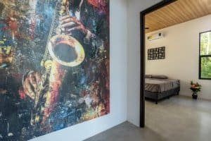 Interior view of a bedroom with a vibrant saxophone mural on the wall.
