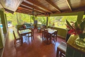Relaxing jungle hotel lounge with seating, lush greenery, and river views in Dominical.