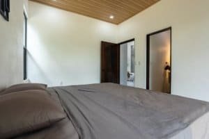 Creekside bedroom with large bed, modern decor and natural light in Costa Rica.