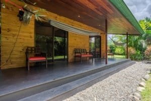 Turn-key 2-bedroom coastal home porch with seating and hammock in Dominical area.