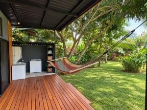 Relaxing hammock on porch overlooking lush garden and trees in Dominical, Costa Rica.