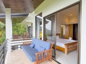Modern bedroom with ocean view, balcony, and garden in Dominical.