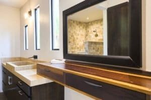 Modern bathroom with large mirror and view of outdoor shower area.