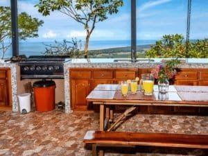 Kitchen with ocean view, tropical rainforest, and outdoor dining area.