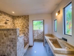 Modern bathroom with stone accents and ocean view in Dominical.