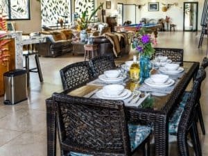 Open-concept living and dining space with tropical decor and natural light.