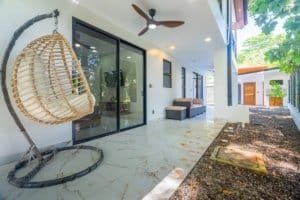 Dominical real estate: modern patio with hanging chair, ceiling fan, and sliding glass doors.