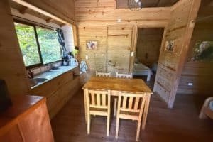 Interior of a wooden jungle hotel with dining area and bedroom in Dominical, Costa Rica.